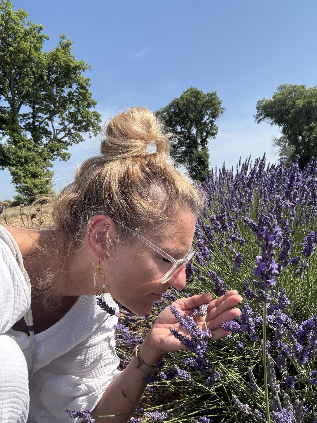 Kathrin riecht an Lavendelblüten in einem Lavendelfeld